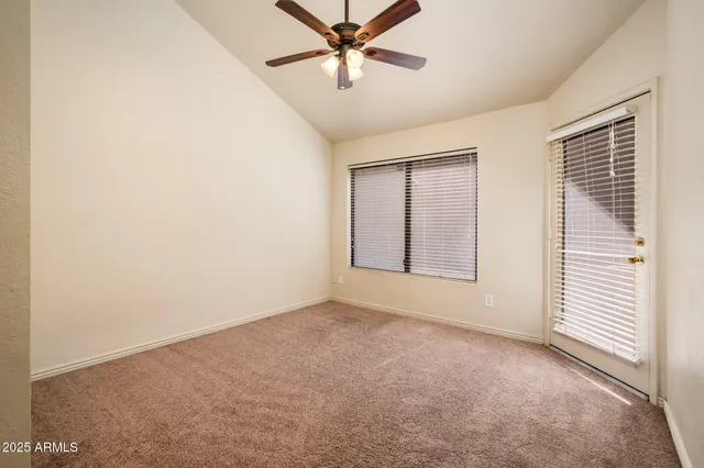 an empty room with windows and fan