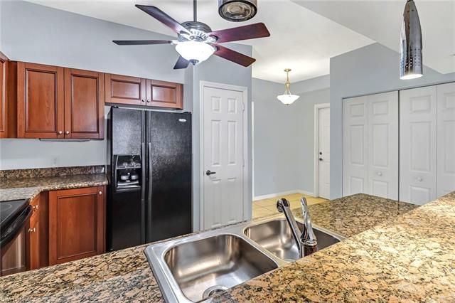 a kitchen with stainless steel appliances granite countertop a refrigerator a sink and a stove