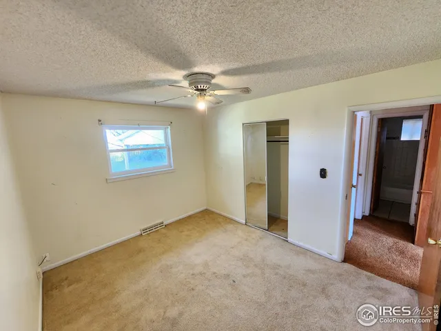 an empty room with fan and entrance