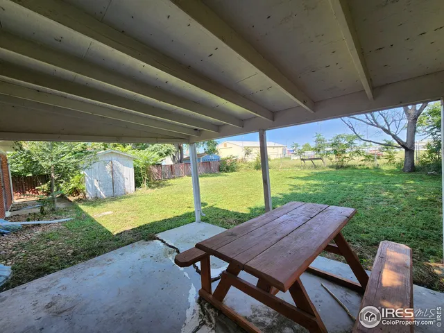a view of a patio with a table chairs and a backyard