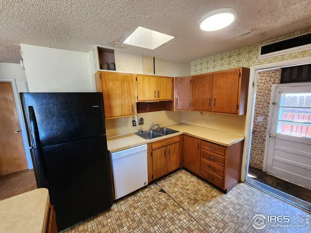 a kitchen with granite countertop wood cabinets and stainless steel appliances