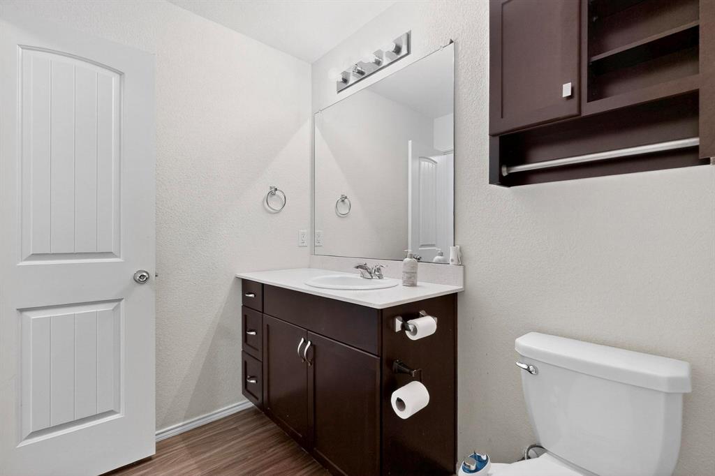 5516 McClelland Street Forney, TX 75126 - Photo 22 of 36 Bathroom with dark wood-type flooring, vanity, and a textured wall