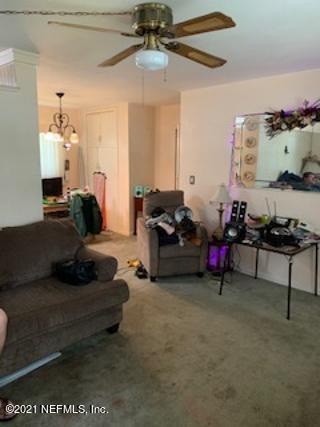 7016 Oakney Road Jacksonville, FL 32211 - Photo 7 of 16 a living room with furniture and a chandelier