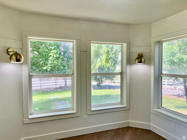 812 East Bates Cyn Road Tooele, UT 84074 - Photo 35 of 144 Bright interior space featuring multiple double-hung windows, contemporary brass wall sconces, wood-finish flooring, white baseboards, and white wall trim