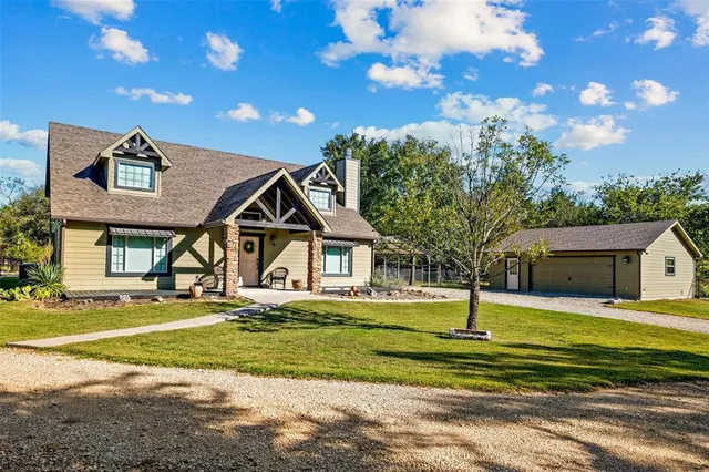 a view of a house with a big yard and potted plants