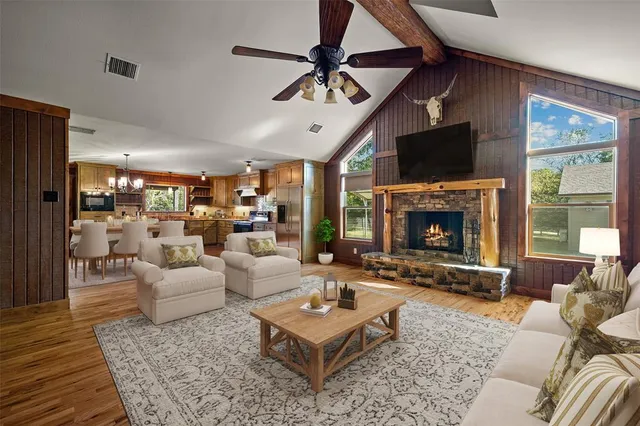 a living room with fireplace furniture and a dining table with kitchen view