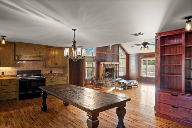 a spacious bedroom with a large bed a chandelier and windows