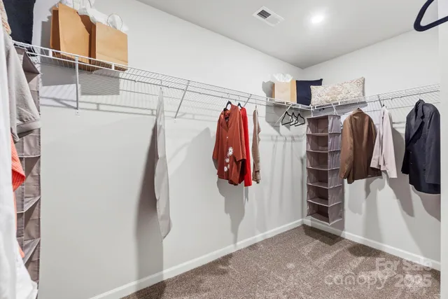 a view of walk in closet with clothes and shoes