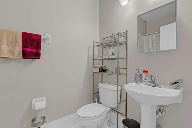 a bathroom with a sink toilet and a mirror