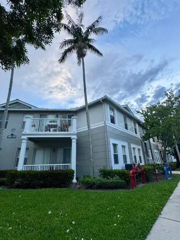 a view of a brick house with a yard and potted plants