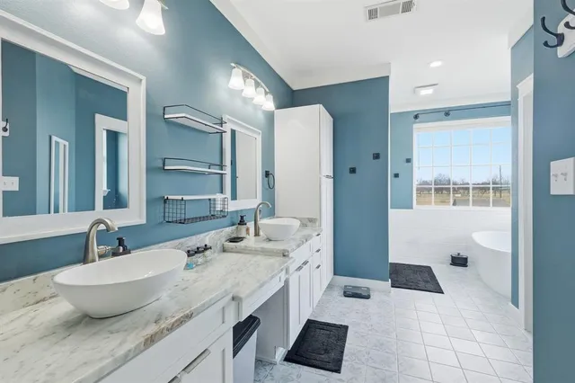 a bathroom with a granite countertop sink and a large mirror