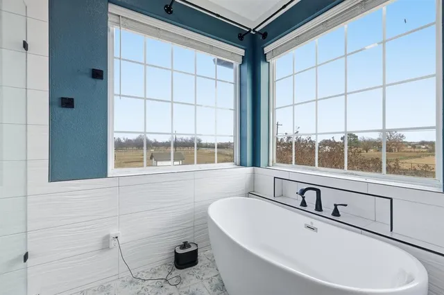 a bathroom with a bathtub and next to a window