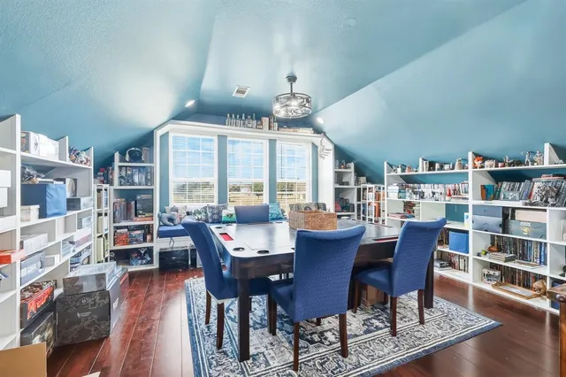 a dining room with furniture a book and wooden floor