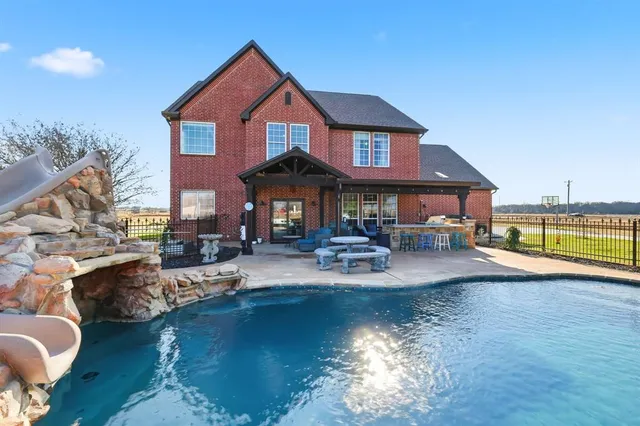 a view of a house with swimming pool and sitting area