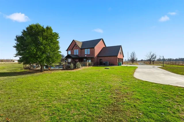 a front view of house with yard and trees in the background