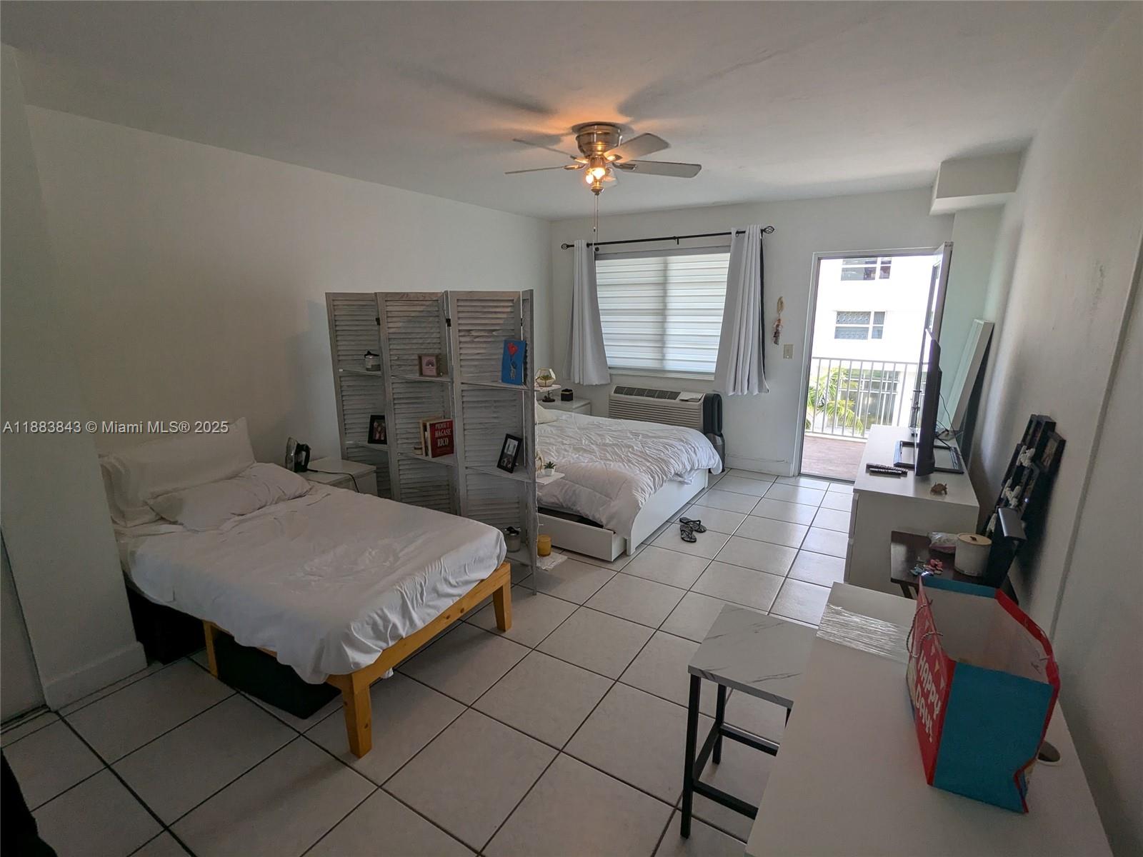 158 Ocean Drive, Unit 406 Miami Beach, FL 33139 - Photo 2 of 6 a spacious bedroom with two beds and a chandelier