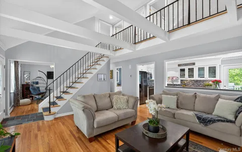 a living room with furniture and a dining table with wooden floor