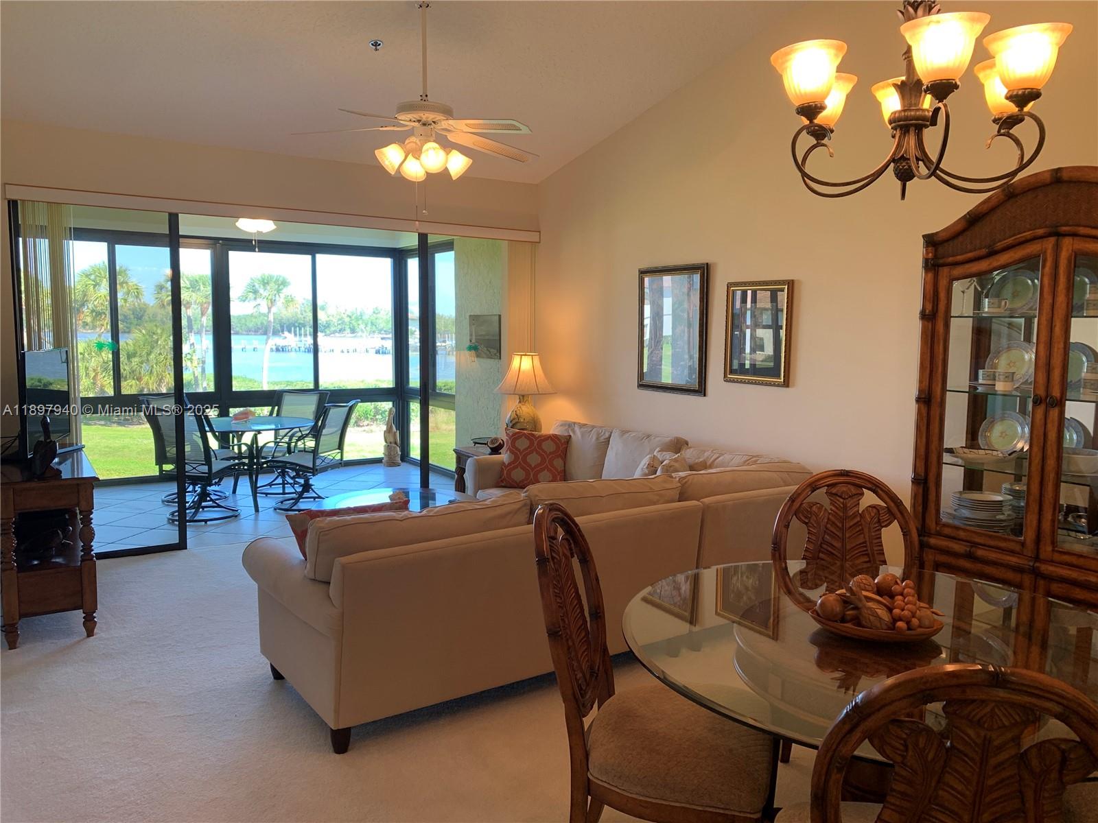 6062 Southeast Landing Way, Unit 15 Stuart, FL 34997 - Photo 12 of 43 a living room with furniture and a chandelier