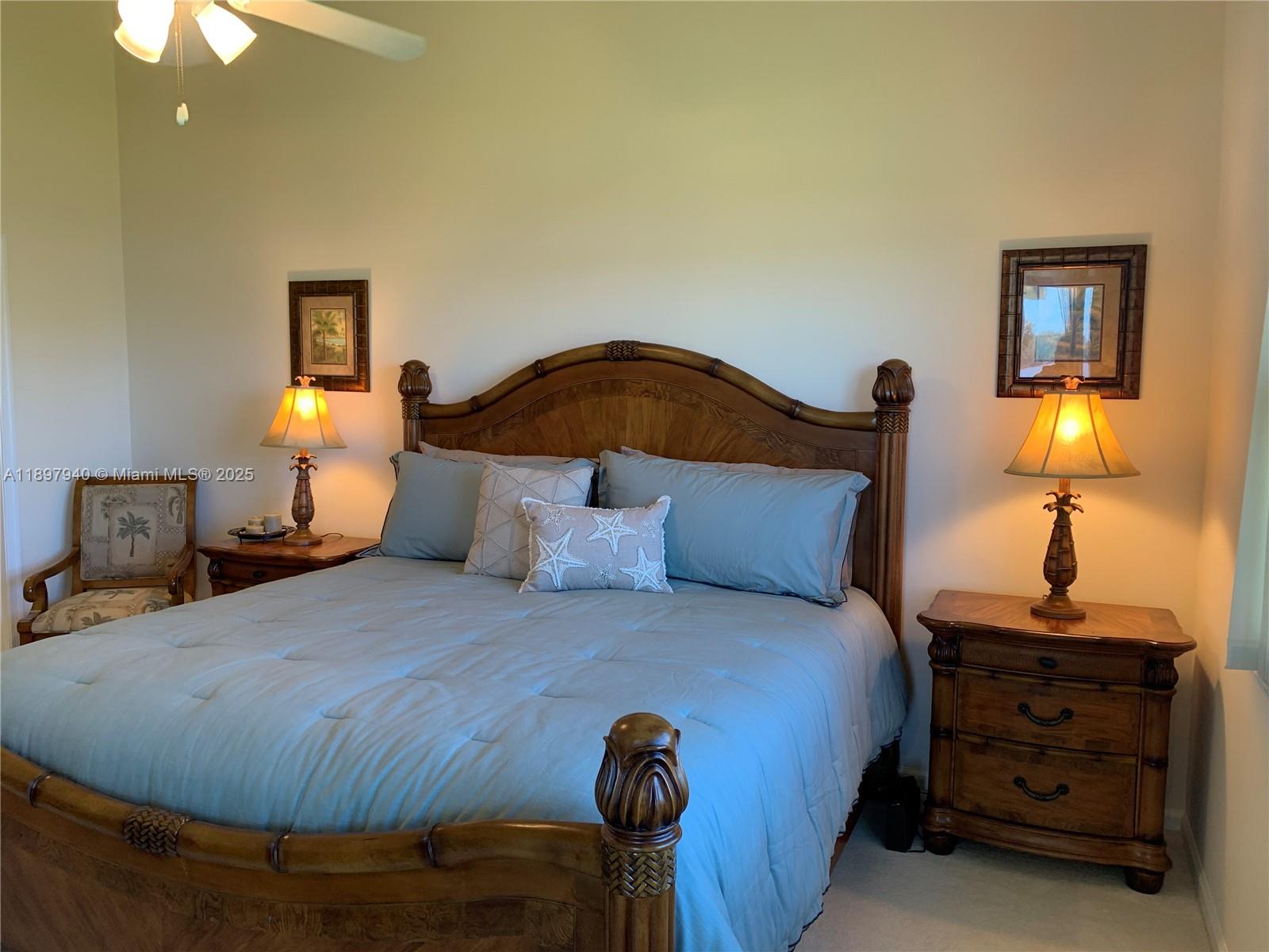 6062 Southeast Landing Way, Unit 15 Stuart, FL 34997 - Photo 19 of 43 a bedroom with a bed and lamp