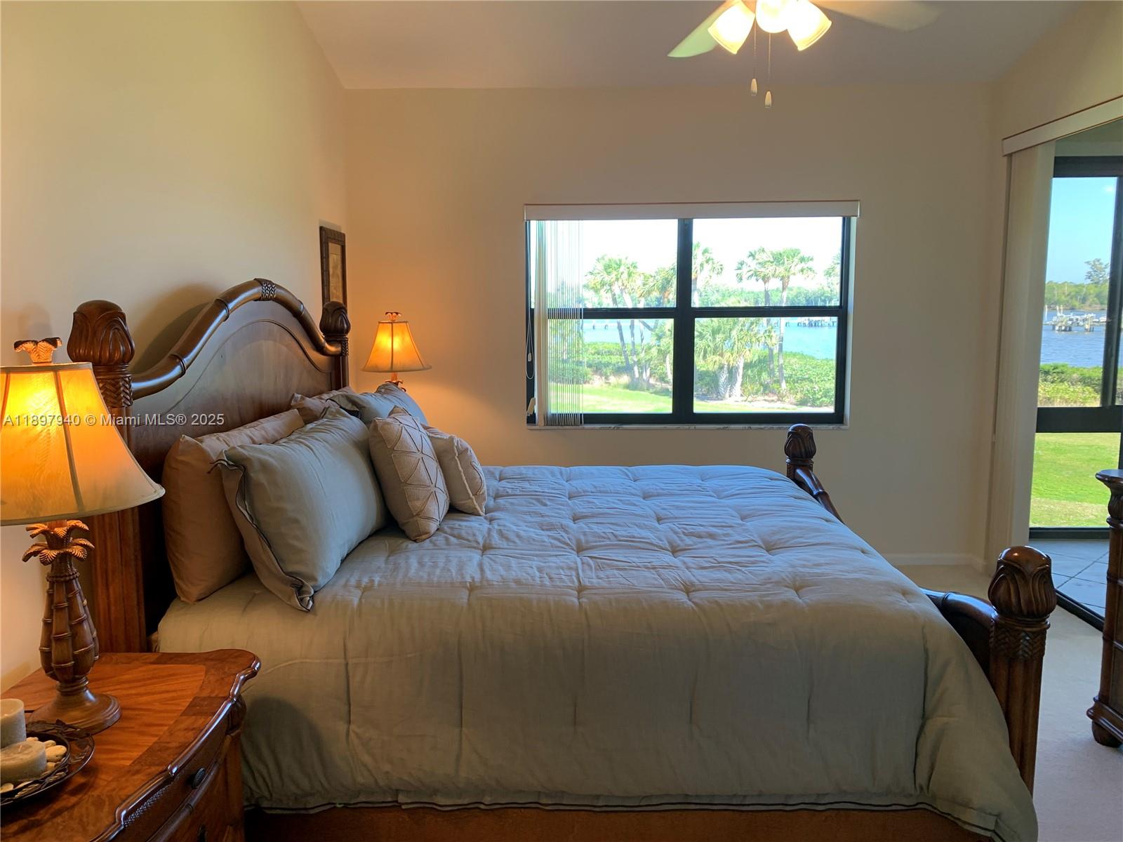 6062 Southeast Landing Way, Unit 15 Stuart, FL 34997 - Photo 20 of 43 a bedroom with a bed and a chandelier