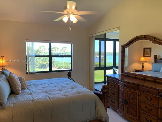 a bedroom with a bed and a dresser next to a window