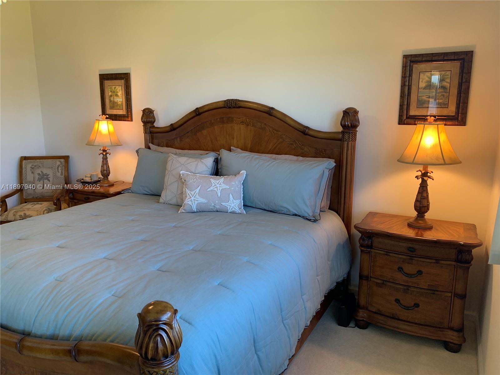 6062 Southeast Landing Way, Unit 15 Stuart, FL 34997 - Photo 22 of 43 a bedroom with a bed and a lamp