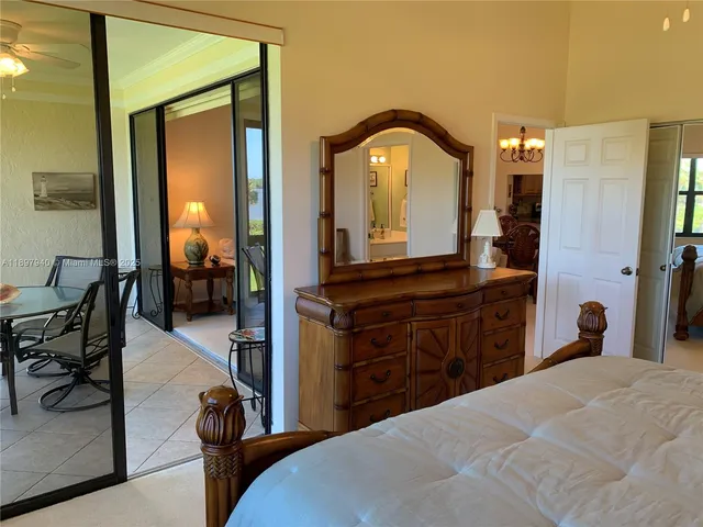 a bedroom with a bed and a mirror on dresser