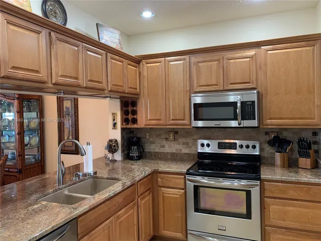 a kitchen with stainless steel appliances granite countertop a sink stove and microwave