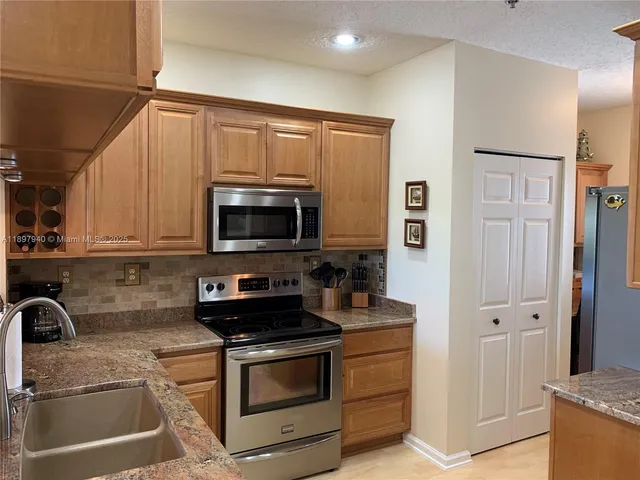 a kitchen with stainless steel appliances granite countertop a stove a sink and a microwave