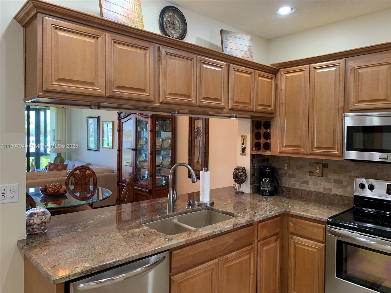 6062 Southeast Landing Way, Unit 15 Stuart, FL 34997 - Photo 9 of 43 a kitchen with granite countertop a sink stove and cabinets