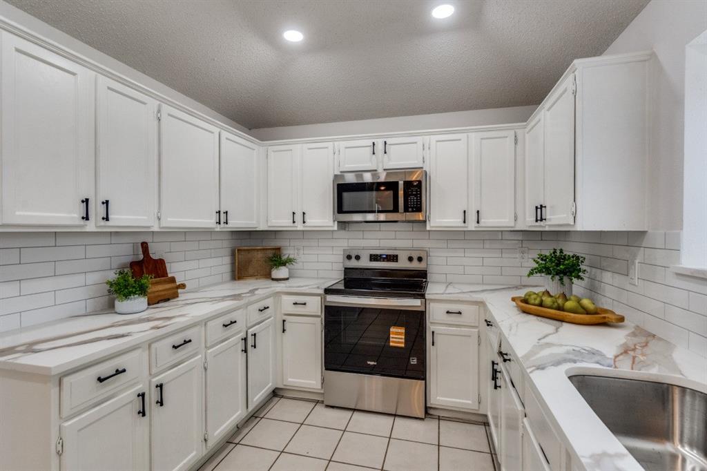 1509 Clover Drive Allen, TX 75002 - Photo 17 of 25 a kitchen with a sink white cabinets and white appliances