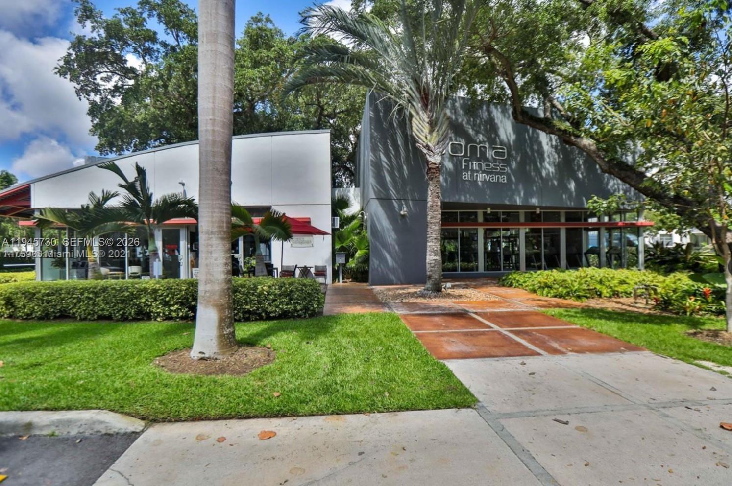 680 Northeast 64th Street, Unit A209 Miami, FL 33138 - Photo 3 of 5 a view of a white house with a yard and large tree