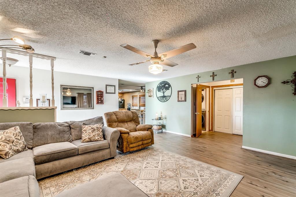 2912 Farm To Market 920 Weatherford, TX 76088 - Photo 12 of 28 Living room featuring ceiling fan, a textured ceiling, wood finished floors, visible vents, and baseboards