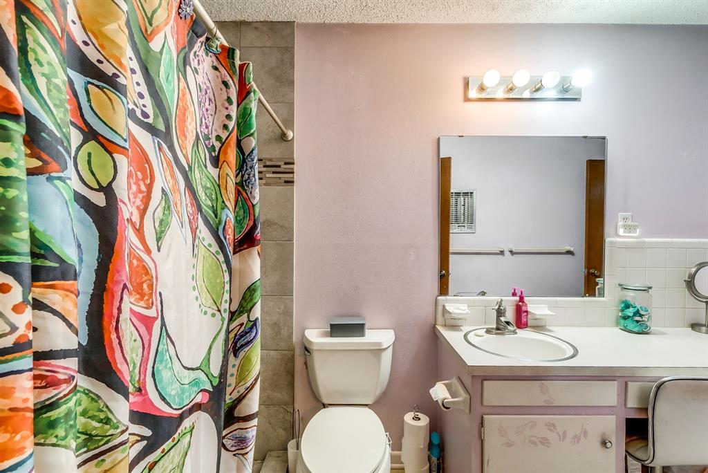 2912 Farm To Market 920 Weatherford, TX 76088 - Photo 17 of 28 Bathroom featuring a textured ceiling, curtained shower, toilet, vanity, and tasteful backsplash