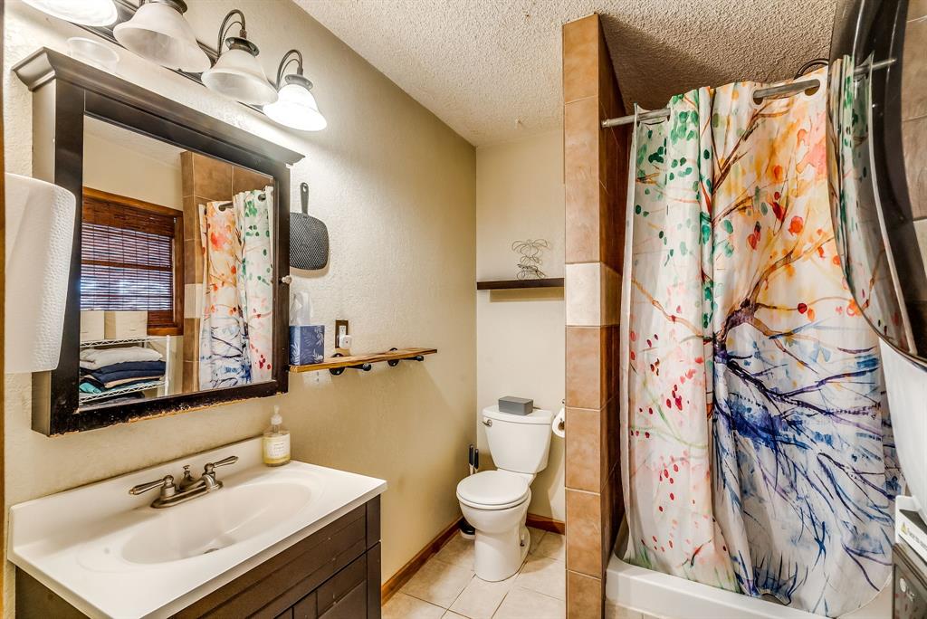 2912 Farm To Market 920 Weatherford, TX 76088 - Photo 21 of 28 Bathroom featuring a shower with shower curtain, toilet, tile patterned floors, a textured ceiling, and vanity