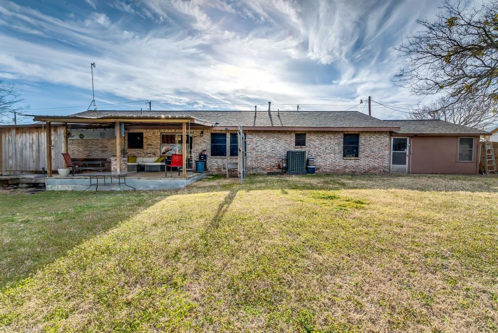 2912 Farm To Market 920 Weatherford, TX 76088 - Photo 25 of 28 Back of house featuring brick siding, a yard, central AC unit, and a patio