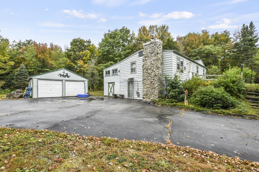 285 Abel Road Rindge, NH 03461 - Photo 1 of 39 a front view of a house with a yard and garage