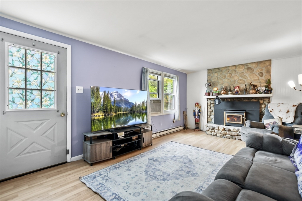 285 Abel Road Rindge, NH 03461 - Photo 2 of 39 a living room with furniture a flat screen tv and a fireplace