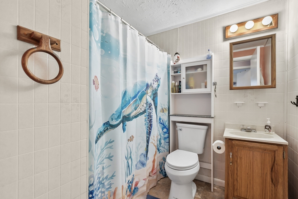 285 Abel Road Rindge, NH 03461 - Photo 21 of 39 a white toilet sitting next to a bathroom sink and a mirror