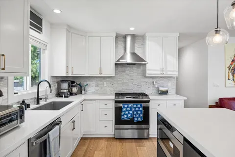 a kitchen with stainless steel appliances a sink stove and cabinets