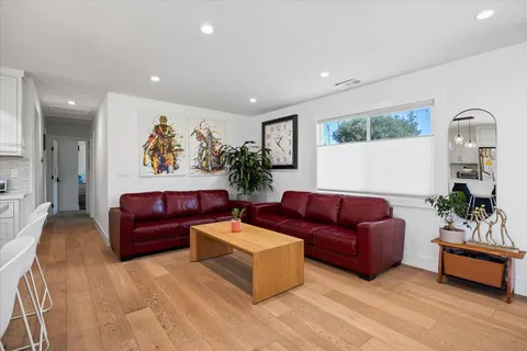 a living room with furniture mirror and painting on the wall