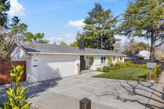 a view of a white house with a large tree and a yard
