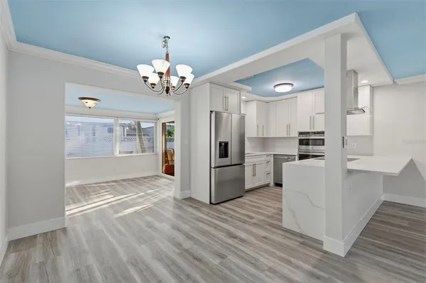 a view of a kitchen with wooden floor and a refrigerator