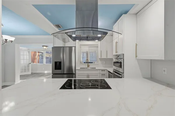 a kitchen with stainless steel appliances granite countertop a sink a stove and a refrigerator