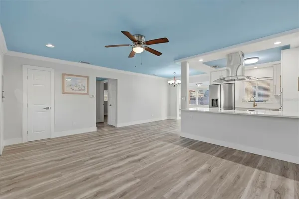 a view of a kitchen with wooden floor and a ceiling fan