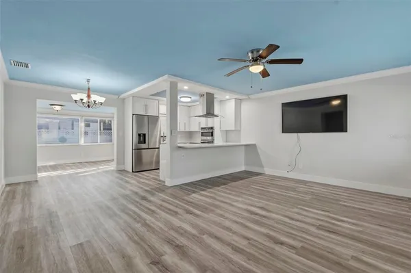 a view of a kitchen with wooden floor and a ceiling fan