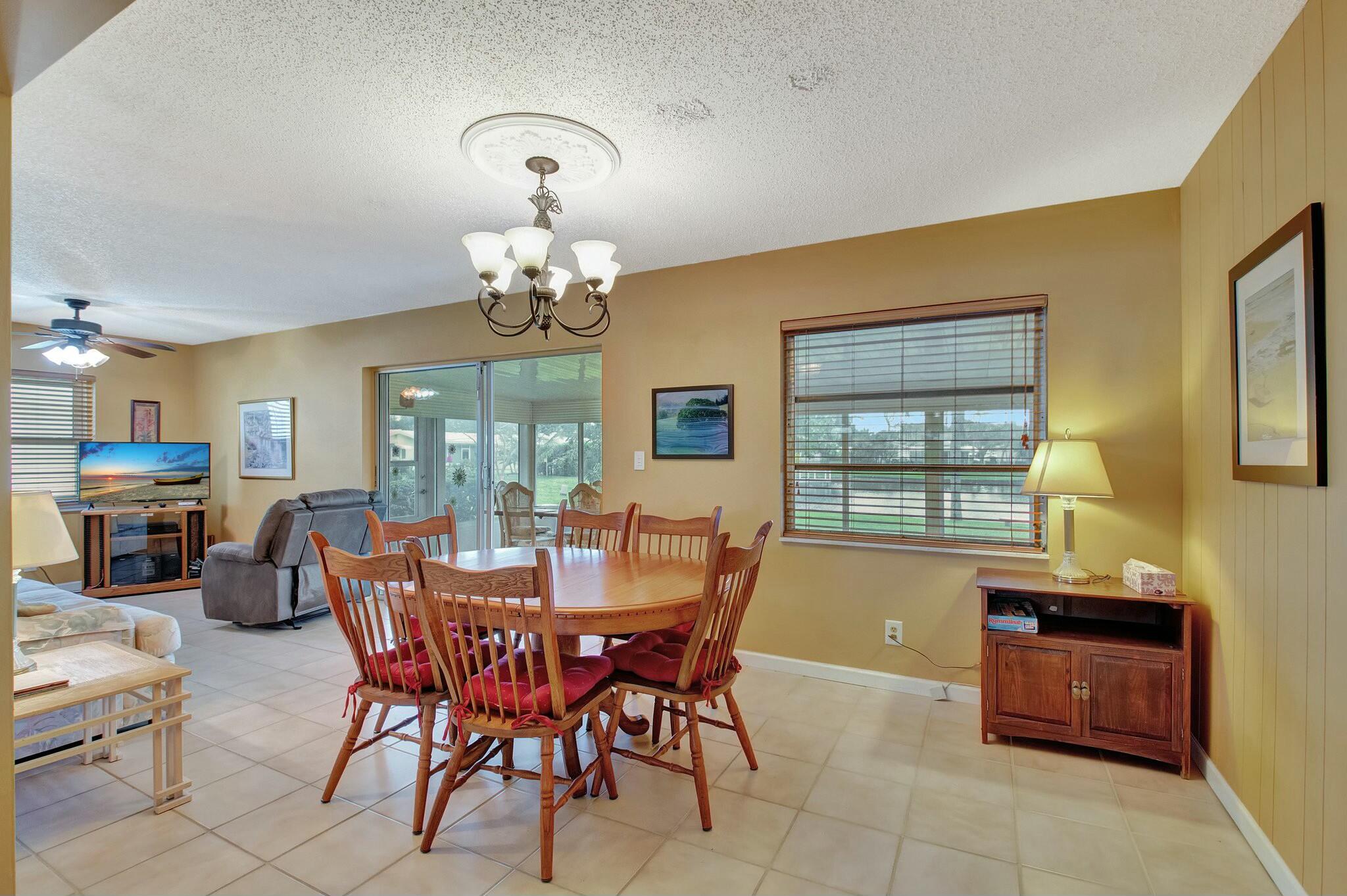 1704 Southwest 16th Street Boynton Beach, FL 33426 - Photo 20 of 44 a dining room with a wooden table and chairs