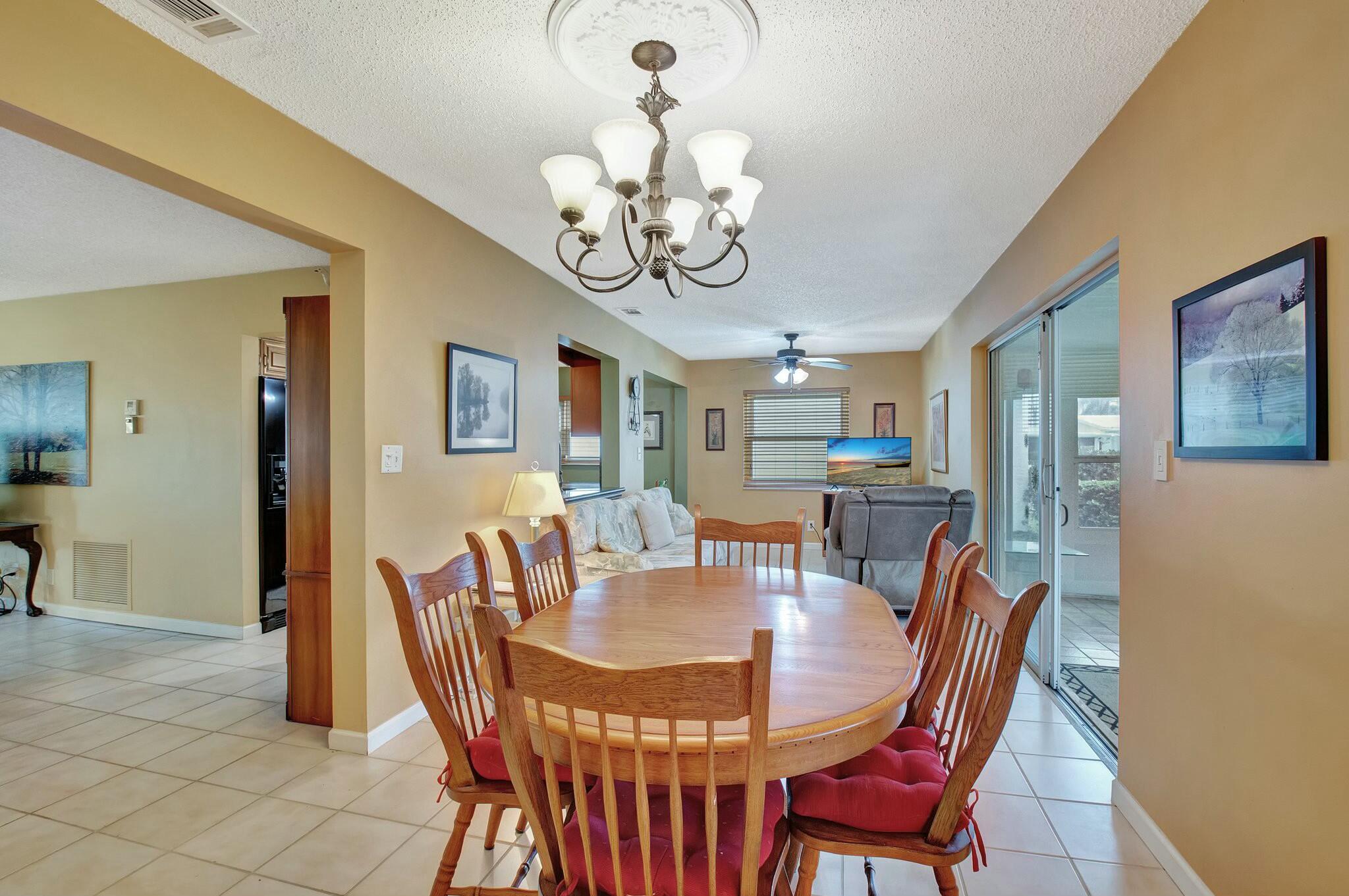 1704 Southwest 16th Street Boynton Beach, FL 33426 - Photo 21 of 44 a view of a dining room with furniture a chandelier and wooden floor