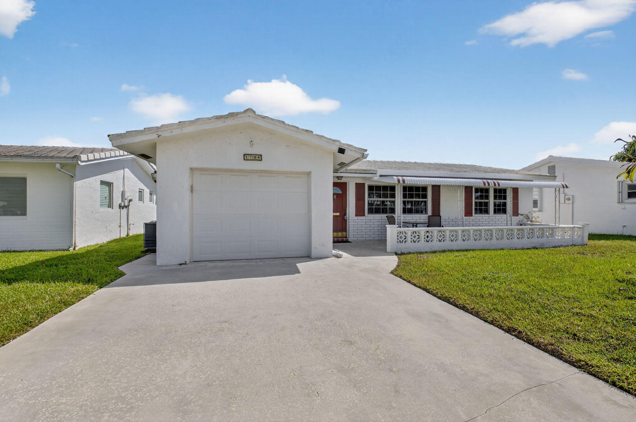 1704 Southwest 16th Street Boynton Beach, FL 33426 - Photo 10 of 44 a front view of a house with a yard and garage