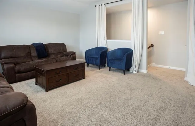 a living room with furniture a ceiling fan and a wooden floor